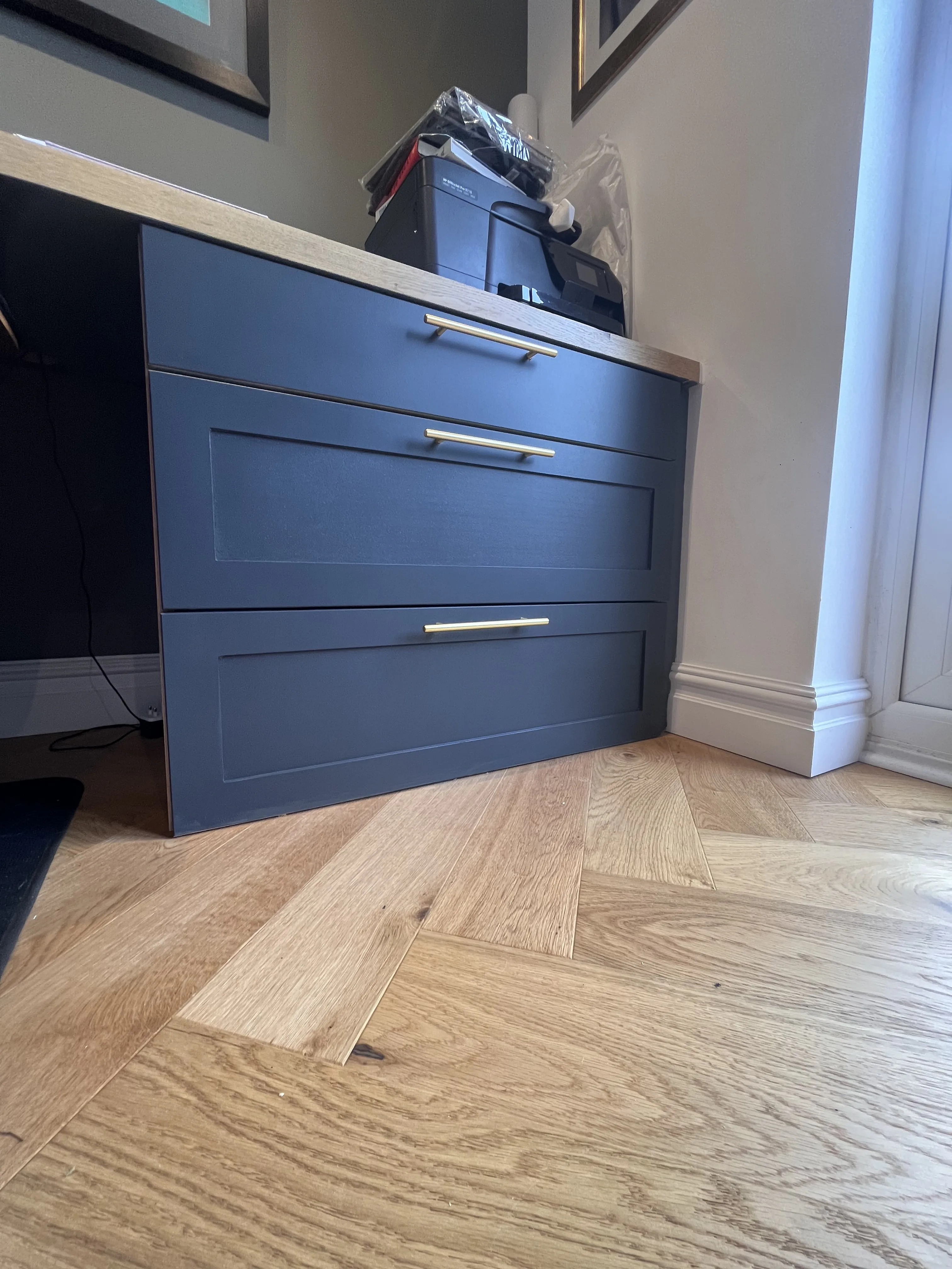 Bespoke dark grey cabinetry with brass handles and herringbone floor