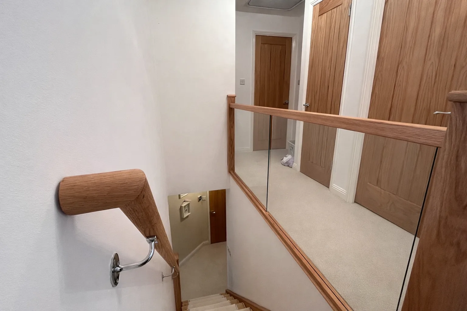 Stair refurbishment with glass panel and oak handrail by LM Carpentry in Neath