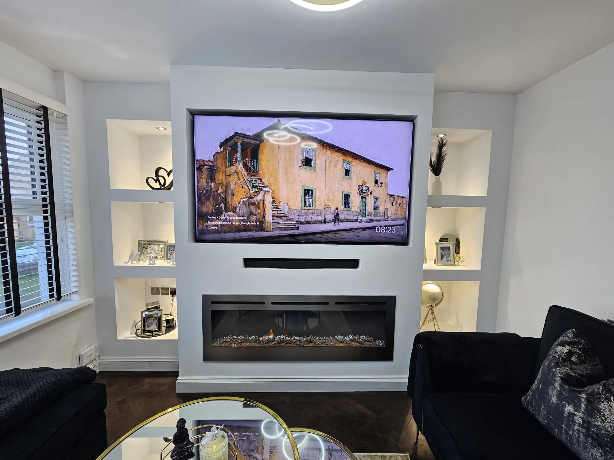 Luxury media wall with TV, electric fireplace, and alcove shelving in Swansea
