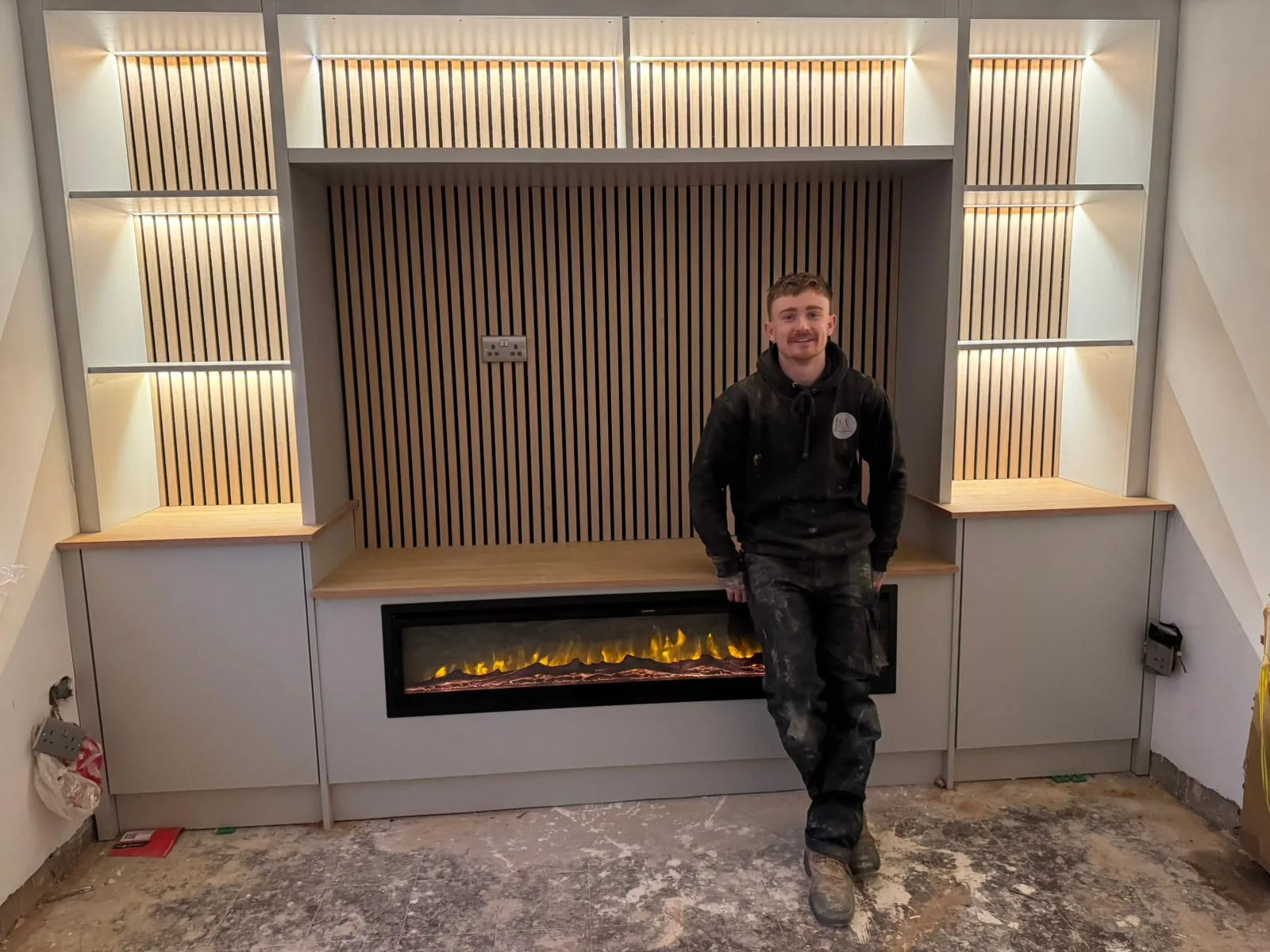 Leigh Morgan of LM Carpentry with a newly installed fireplace media wall in Neath Port Talbot