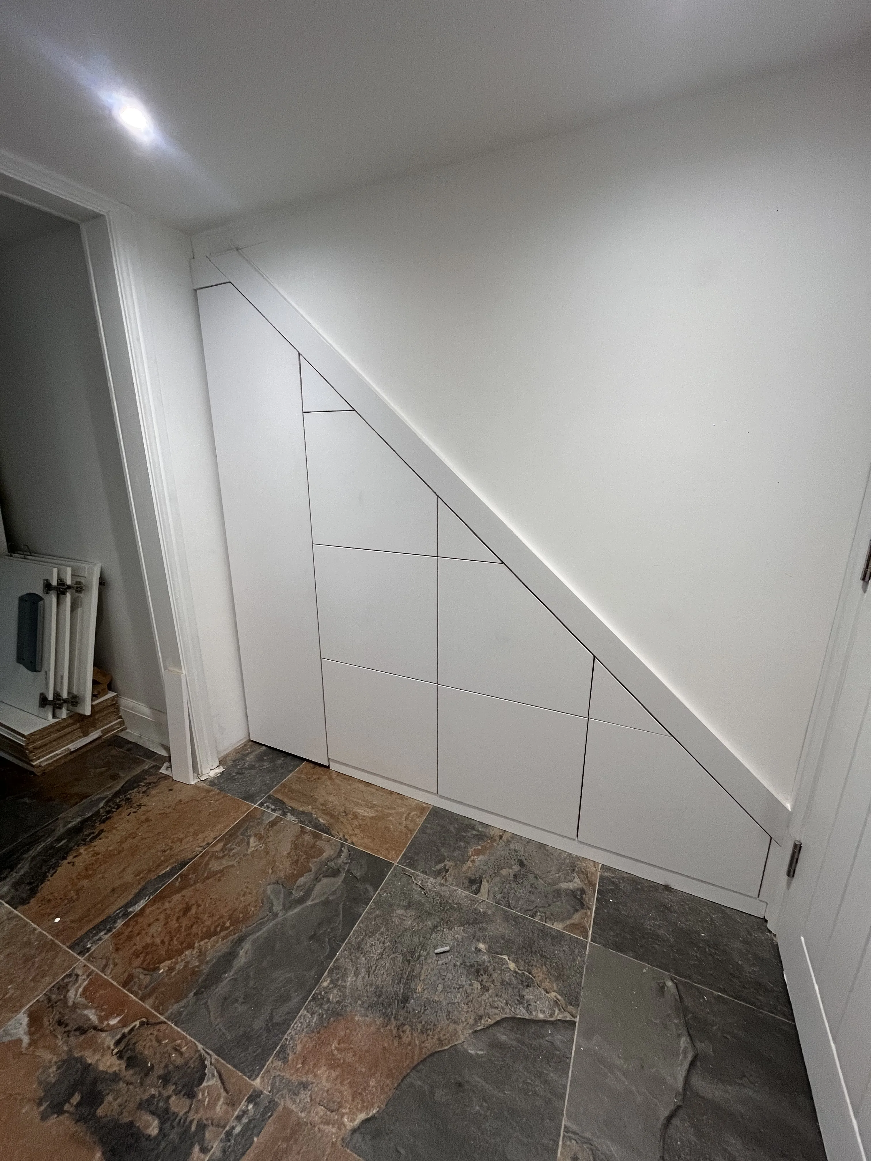 White push-to-open under stairs storage with slate floor in Neath